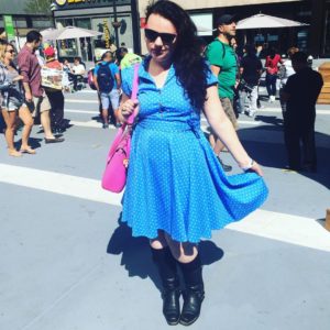 me wearing a blue polka-dotted dress and sunglasses in a busy New York square