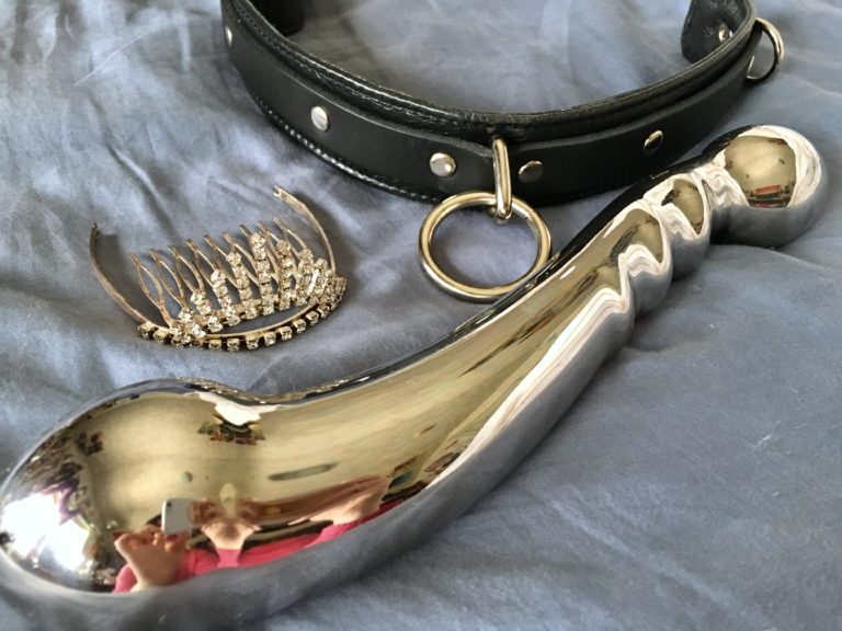 a collar, a tiara, and a massive steel dildo